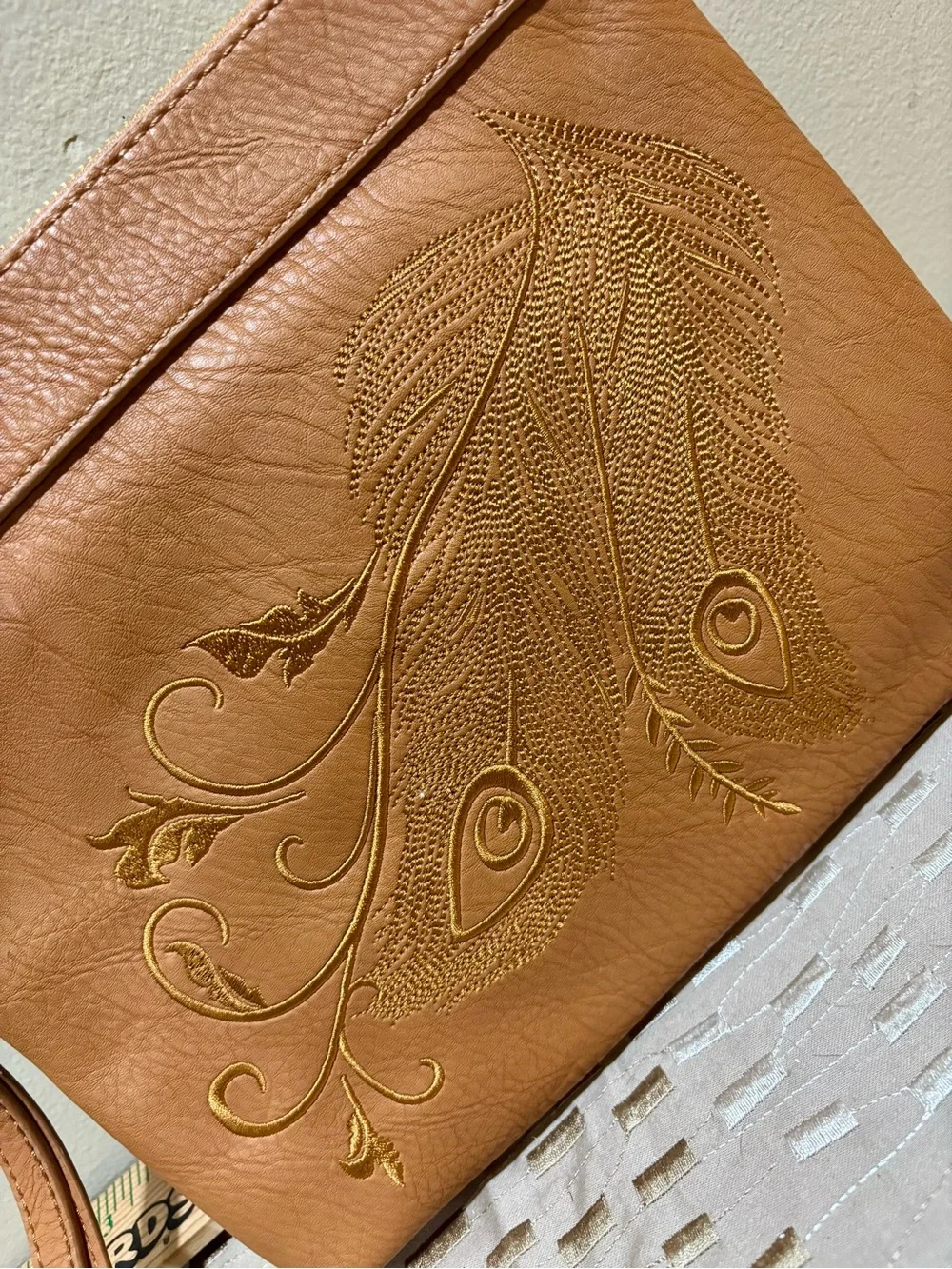 Charming Charlie Tan Wristlet Clutch with Embossed Feather Motif